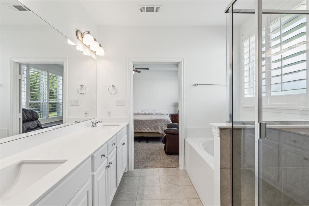 2410 Black Jack Oak Road Terrell, TX 75161 - Photo 22 of 31 Ensuite bathroom with double vanity, a bath, tile patterned flooring, a stall shower, and a ceiling fan