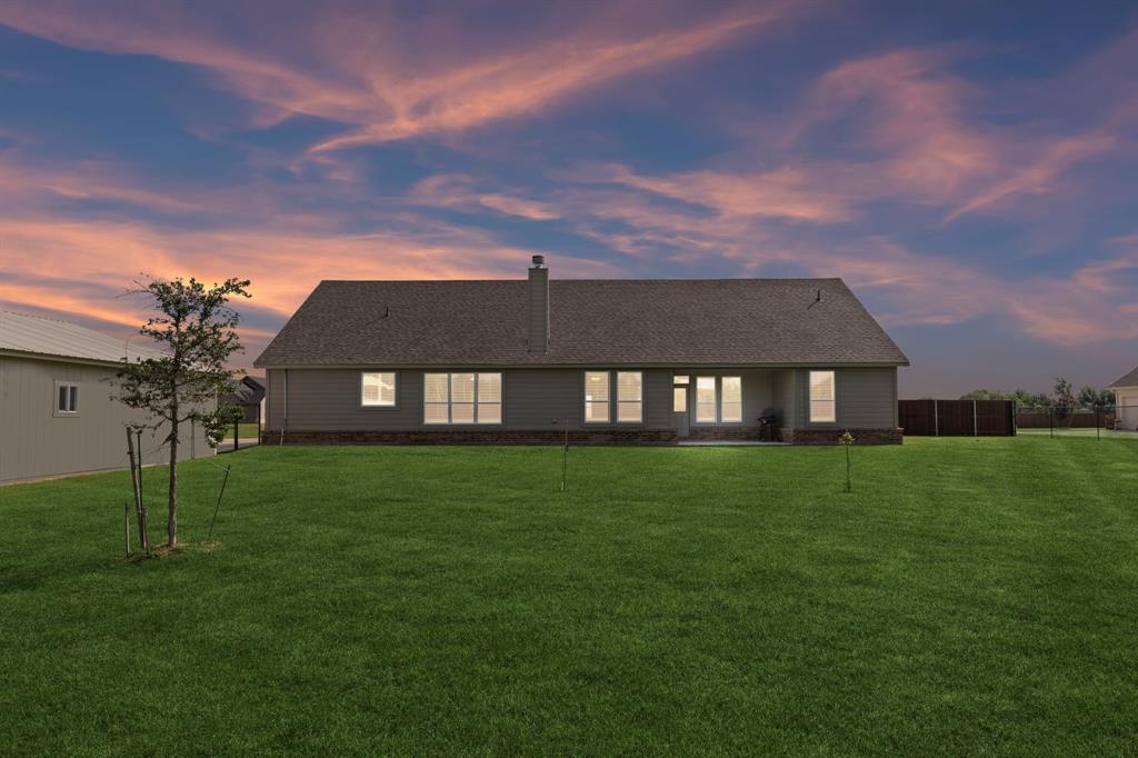2410 Black Jack Oak Road Terrell, TX 75161 - Photo 29 of 31 Back of house at dusk with a chimney, a yard, and a shingled roof