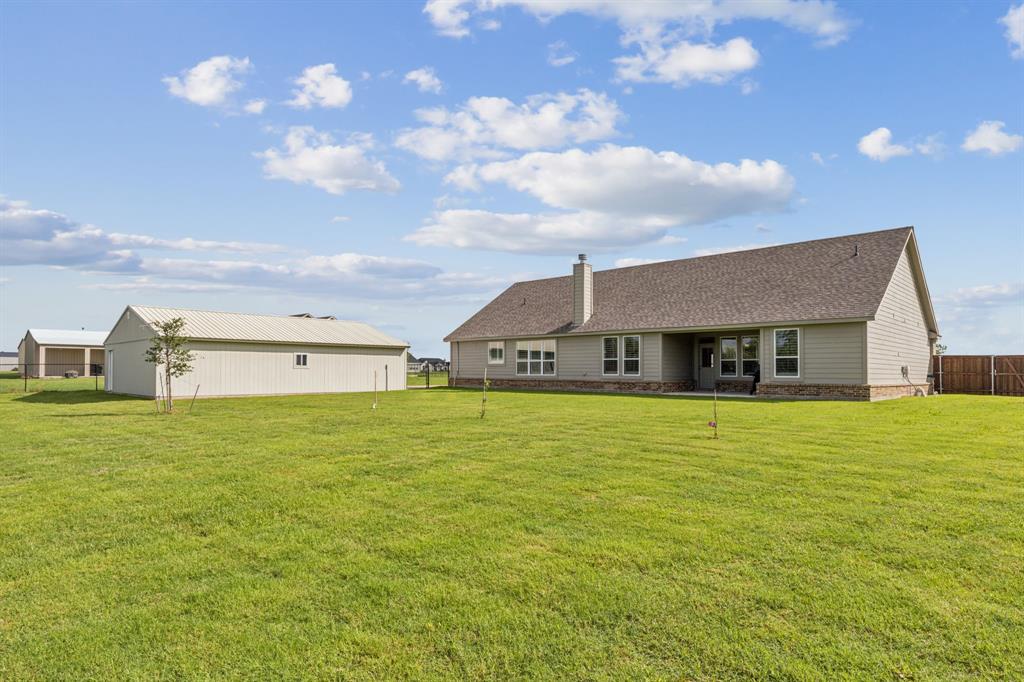2410 Black Jack Oak Road Terrell, TX 75161 - Photo 30 of 31 Rear view of house with a shingled roof and a chimney