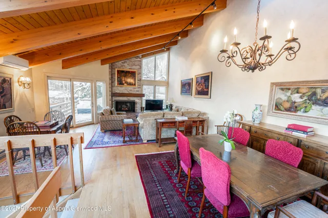 a living room with furniture kitchen view and a large window