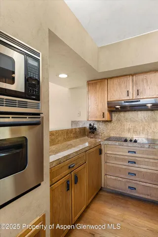 a kitchen with stainless steel appliances granite countertop a stove and cabinets