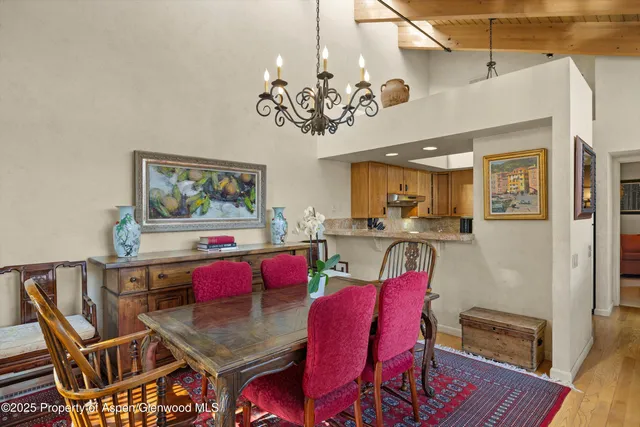 a view of a dining room with furniture a chandelier and wooden floor