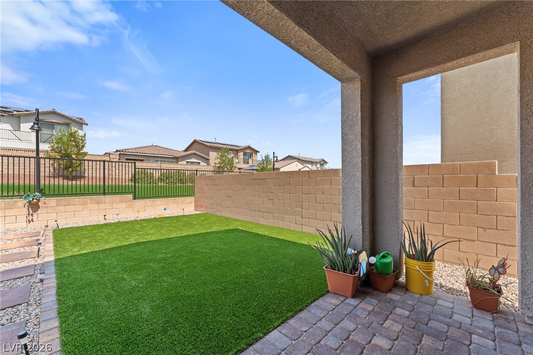 8879 Roadrunner Ravine Street Las Vegas, NV 89166 - Photo 39 of 39 A well-maintained outdoor space features lush artificial turf and a covered patio area.