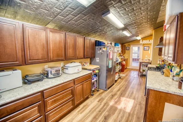 a view of a kitchen with lots of counter space and wooden floor