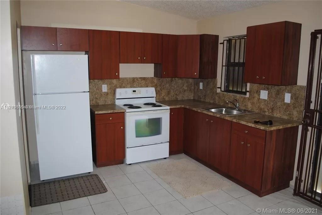 14006 Southwest 281st Terrace Homestead, FL 33033 - Photo 4 of 5 a kitchen with a refrigerator and a stove