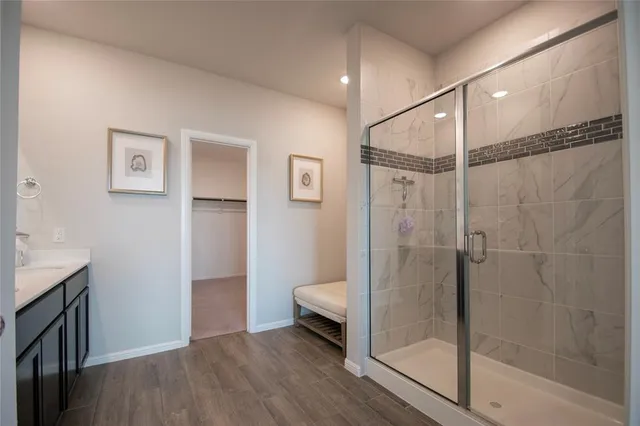 a en suite bathroom with a granite countertop sink and a mirror