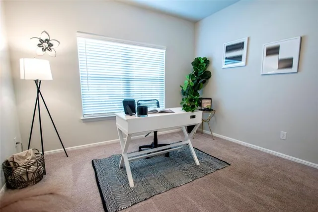 a view of a workspace with furniture and a window