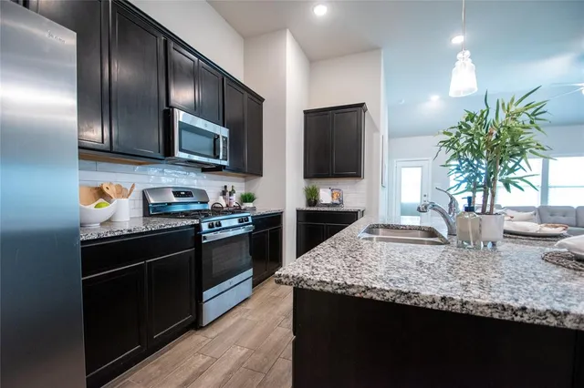 a kitchen with granite countertop stainless steel appliances and wooden cabinets