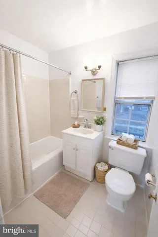 a bathroom with a sink a toilet a mirror and shower