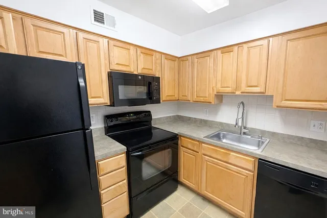 a kitchen with a sink appliances and cabinets