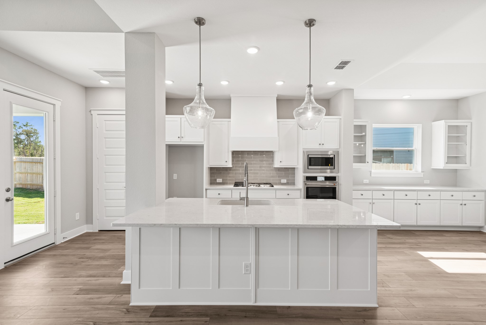 18623 Rumba Court Conroe, TX 77302 - Photo 27 of 48 a large kitchen with kitchen island a large counter space a sink appliances and cabinets