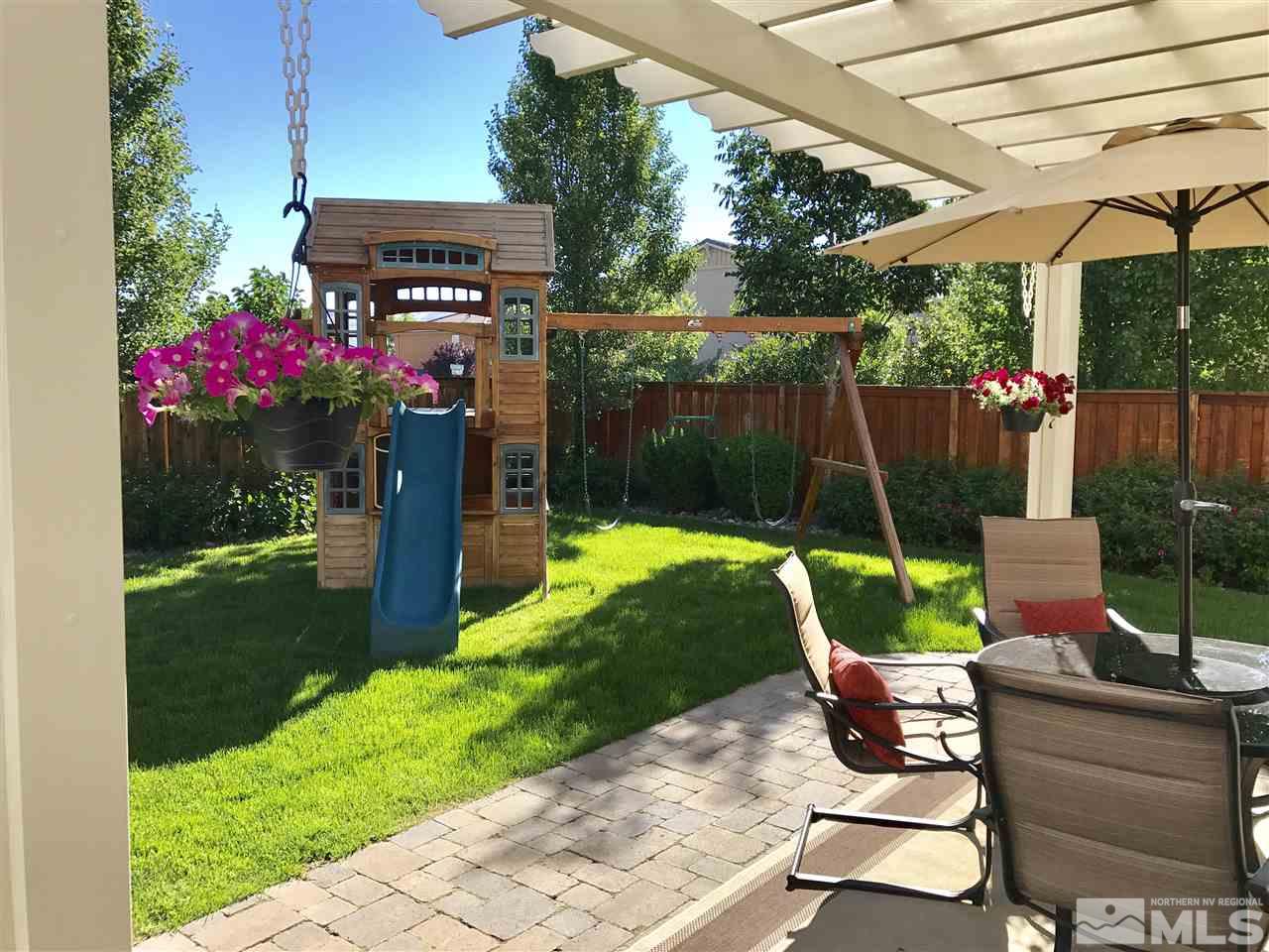 495 Terracina Way Reno, NV 89521 - Photo 23 of 25 a view of a backyard with table and chairs potted plants and palm tree