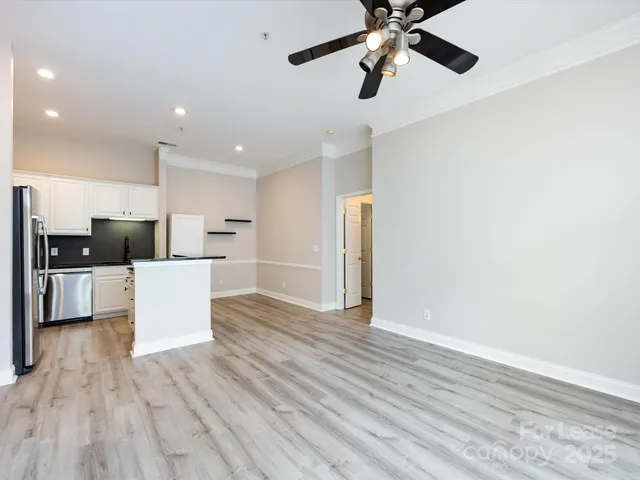 a view of kitchen with stainless steel appliances granite countertop a refrigerator and a stove top oven