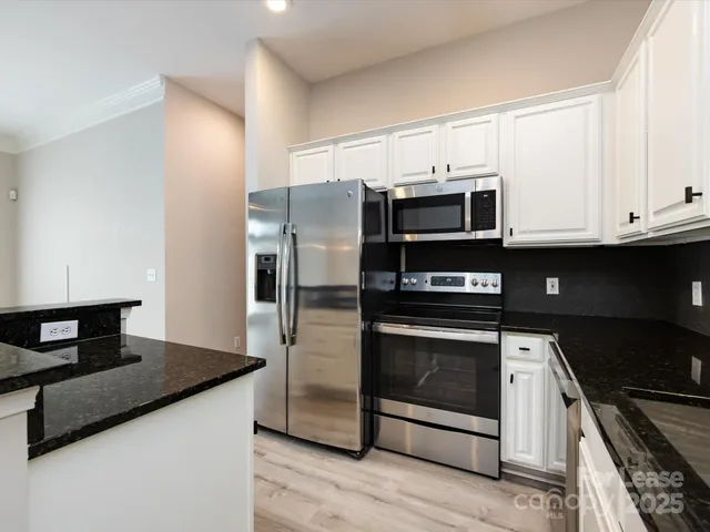 a kitchen with granite countertop a stove and a refrigerator