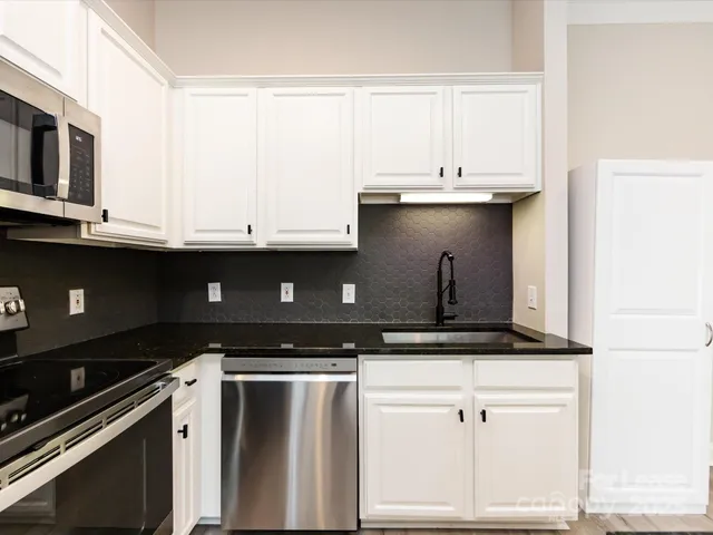 a kitchen with granite countertop a sink and a stove