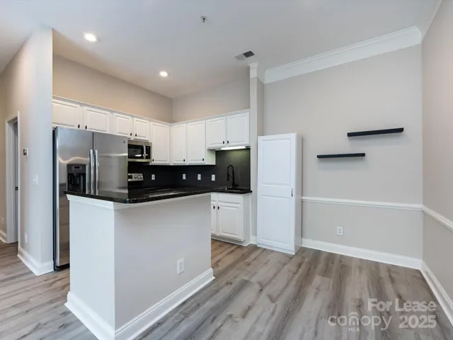a kitchen with stainless steel appliances a refrigerator and a stove top oven
