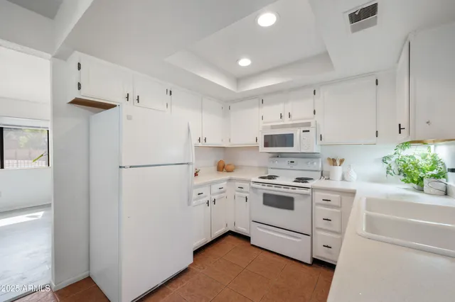 a kitchen with white cabinets and white appliances