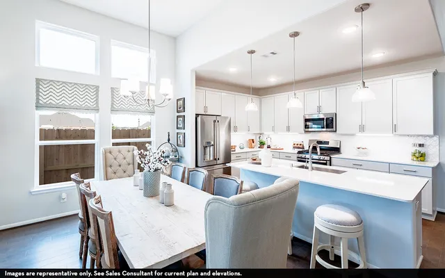 a kitchen with stainless steel appliances granite countertop a dining table chairs stove refrigerator and cabinets