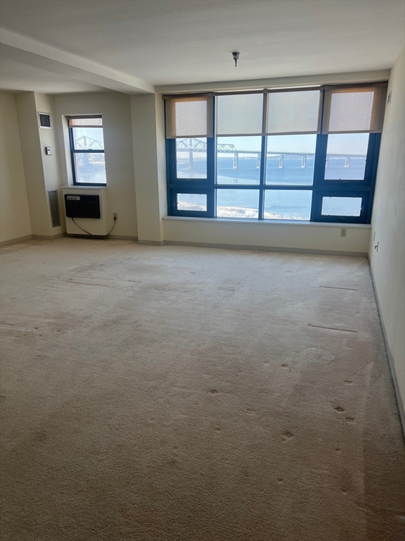 750 Davol Street, Unit 616 Fall River, MA 02720 - Photo 13 of 17 wooden floor in an empty room with a window
