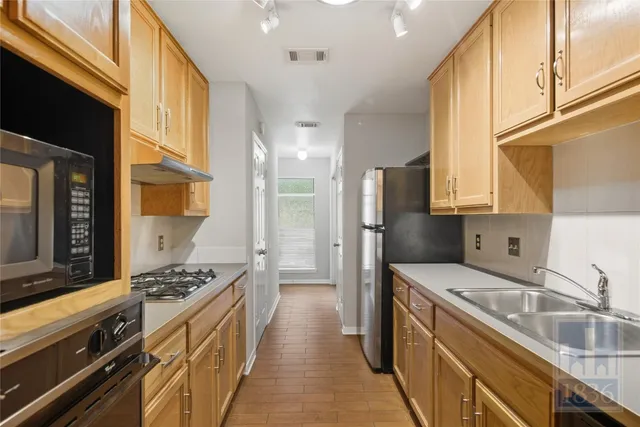a kitchen with stainless steel appliances granite countertop a sink stove and refrigerator