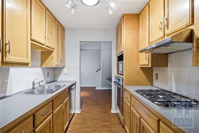 a kitchen with stainless steel appliances a sink a stove and a refrigerator
