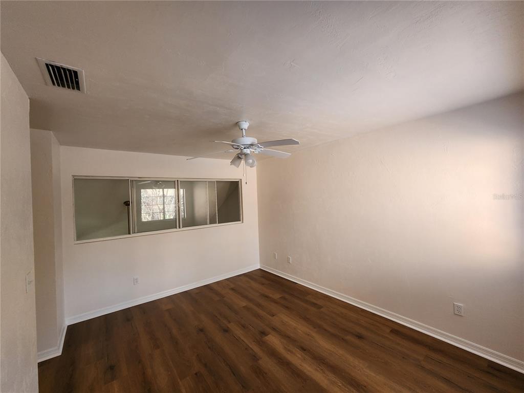 5823 Southwest 9th Place, Unit H55 Gainesville, FL 32607 - Photo 32 of 50 an empty room with wooden floor and windows