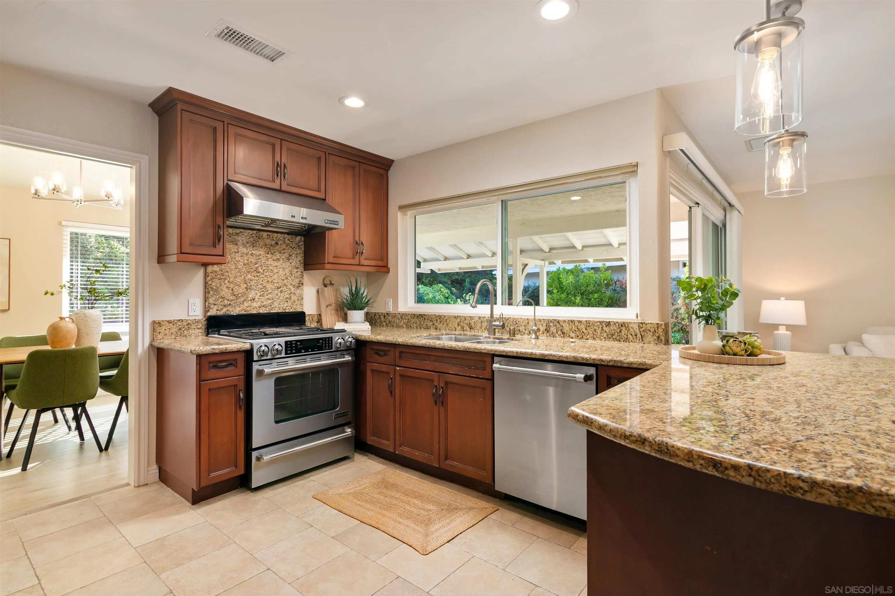 12607 Opimo Drive San Diego, CA 92128 - Photo 17 of 48 a kitchen with granite countertop stainless steel appliances a sink counter space and a large window