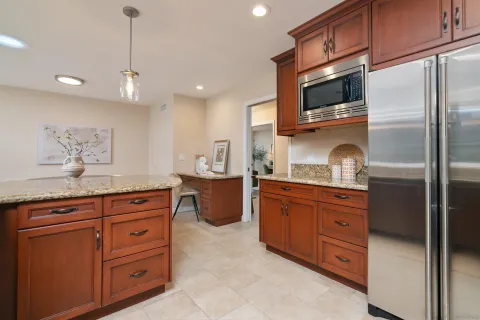 a kitchen with granite countertop a refrigerator and a stove top oven