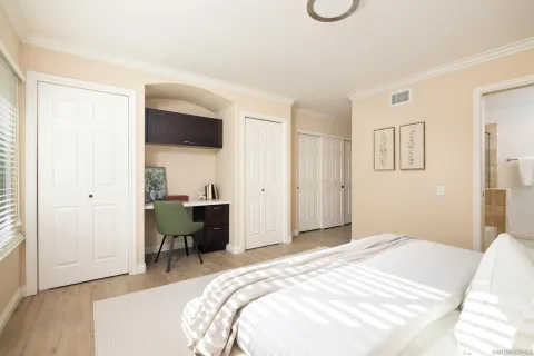 a bedroom with a bed and a chair with the wooden floor