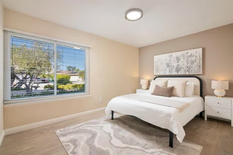 a bedroom with a bed lamp and window