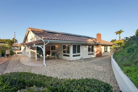 a view of a yard with plants and a bench