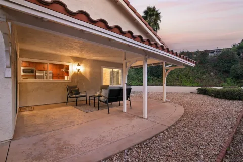 a view of a patio with table and chairs with wooden floor and fence
