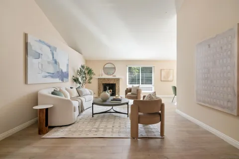 a living room with furniture a fireplace and a large window