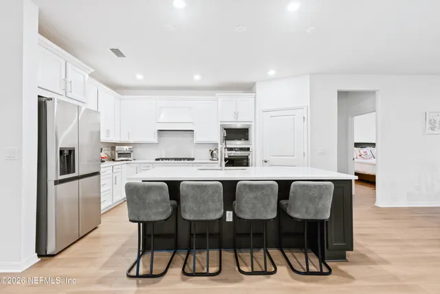 a kitchen with a dining table chairs refrigerator and cabinets