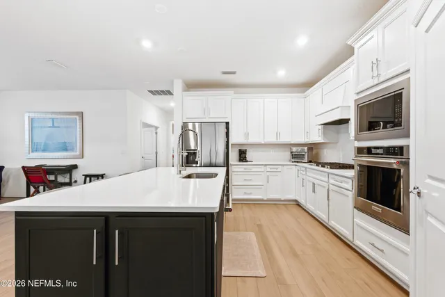 a kitchen with stainless steel appliances a stove refrigerator sink and microwave