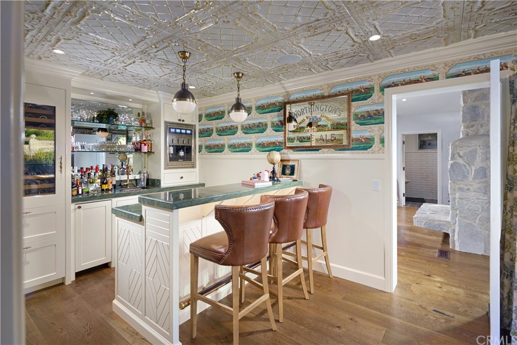 495 Arroyo Chico Laguna Beach, CA 92651 - Photo 10 of 28 a dining room with stainless steel appliances kitchen island granite countertop a table chairs and a view of living room