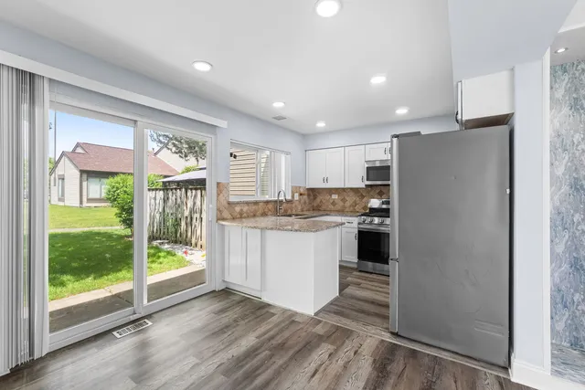 a kitchen with a refrigerator and countertop cabinets