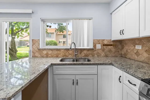 a kitchen with stainless steel appliances granite countertop a sink and a window