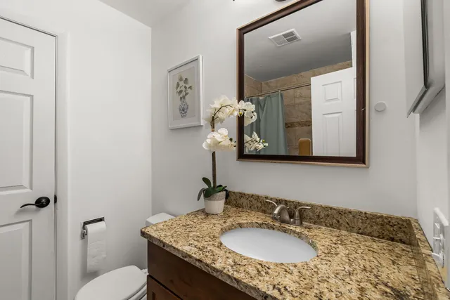 a bathroom with a granite countertop sink and a mirror