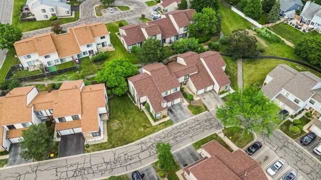 an aerial view of residential houses with outdoor space and street view