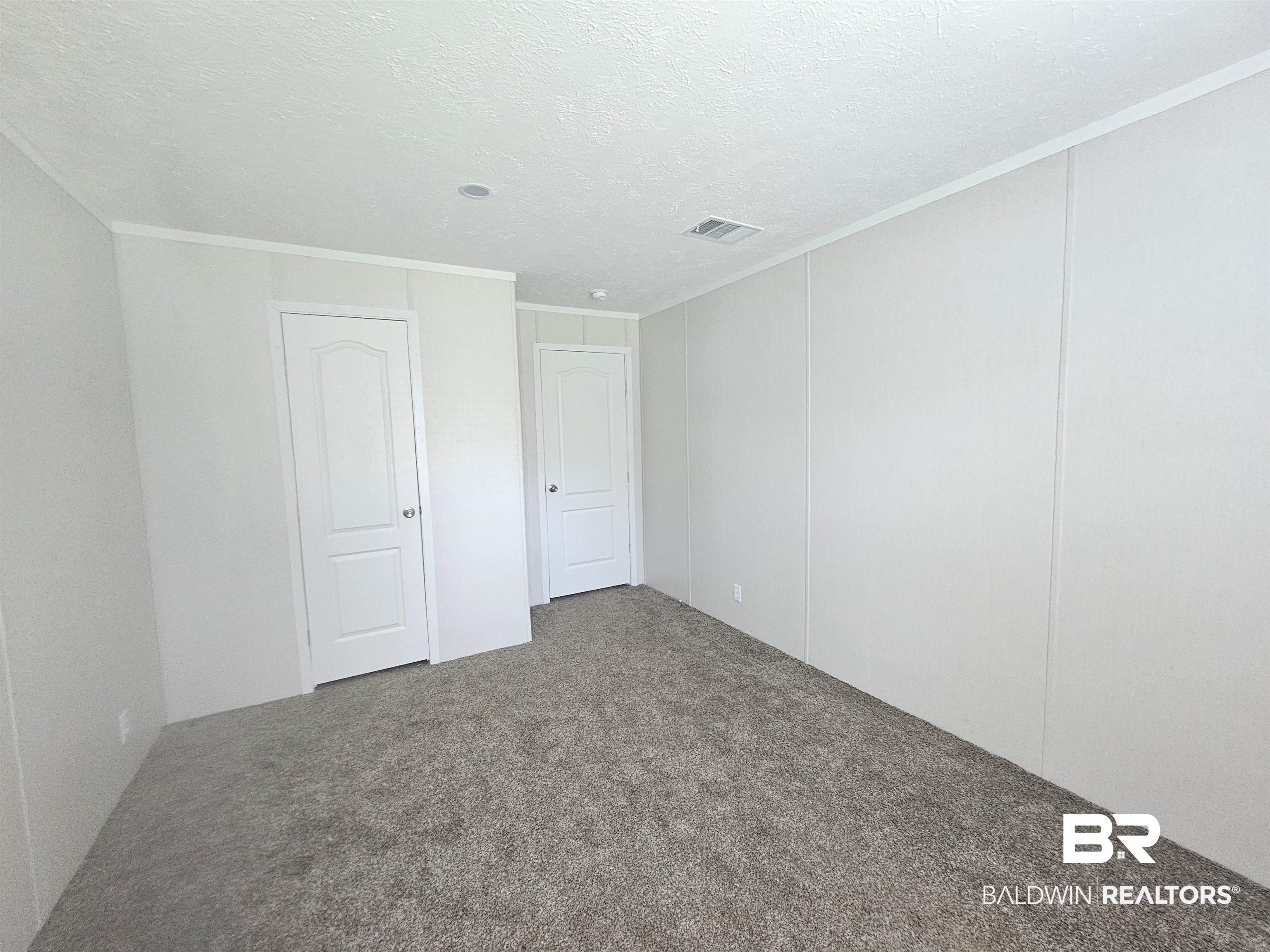 1863 Wait Road Monroeville, AL 36460 - Photo 16 of 38 Unfurnished bedroom featuring crown molding, carpet, and a textured ceiling