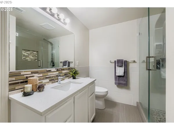 a bathroom with a sink mirror toilet and shower