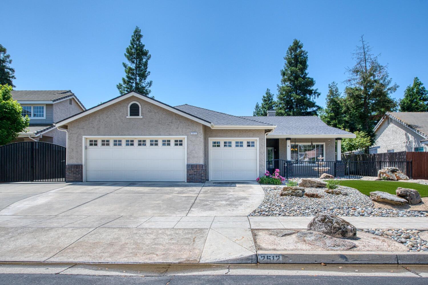 a view of a house with a yard and potted plants