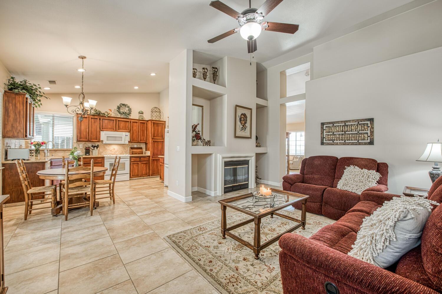 2512 Keats Avenue Clovis, CA 93611 - Photo 18 of 39 a living room with furniture a fireplace and a kitchen view