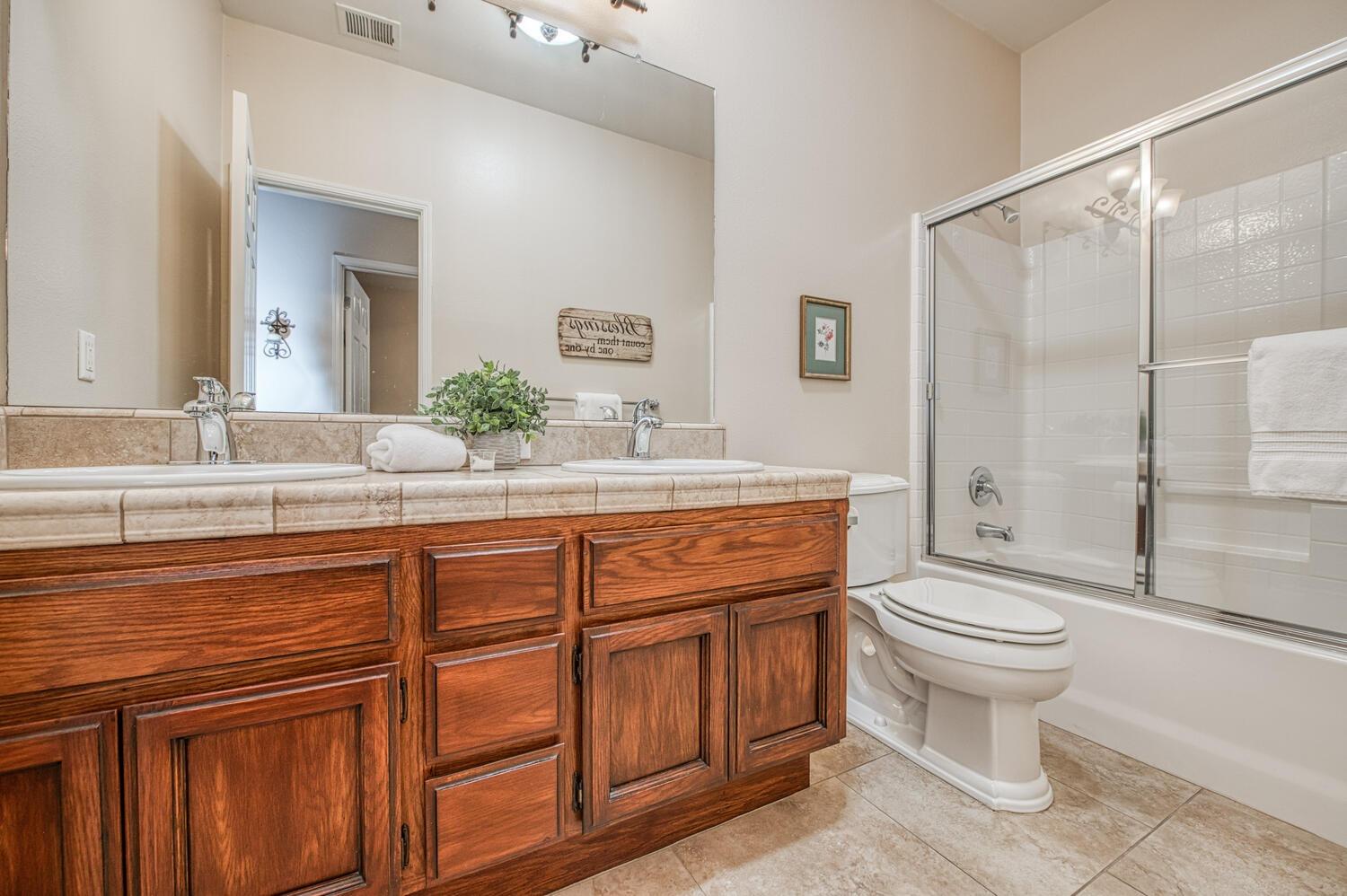 2512 Keats Avenue Clovis, CA 93611 - Photo 25 of 39 a bathroom with a granite countertop toilet sink and mirror