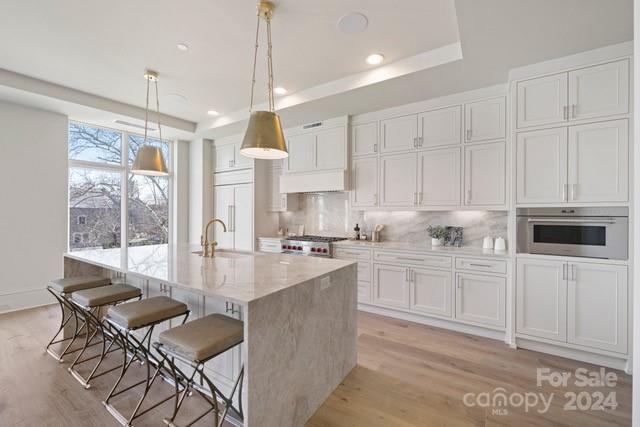 1500 Queens Road, Unit 301 Charlotte, NC 28207 - Photo 3 of 12 a kitchen with kitchen island granite countertop a table chairs sink and cabinets