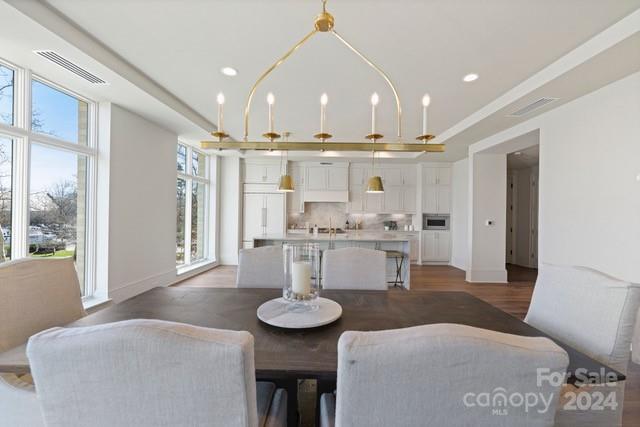 1500 Queens Road, Unit 301 Charlotte, NC 28207 - Photo 5 of 12 a open kitchen with stainless steel appliances kitchen island granite countertop a table and chairs