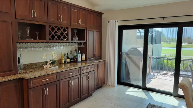 a kitchen with granite countertop a refrigerator a sink and wooden cabinets