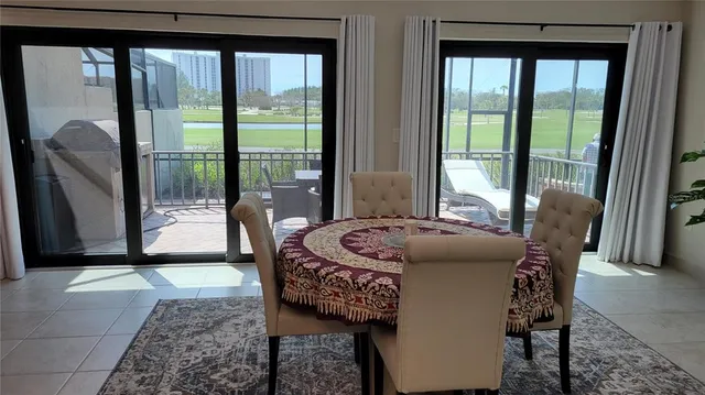 a dining room with furniture and large windows