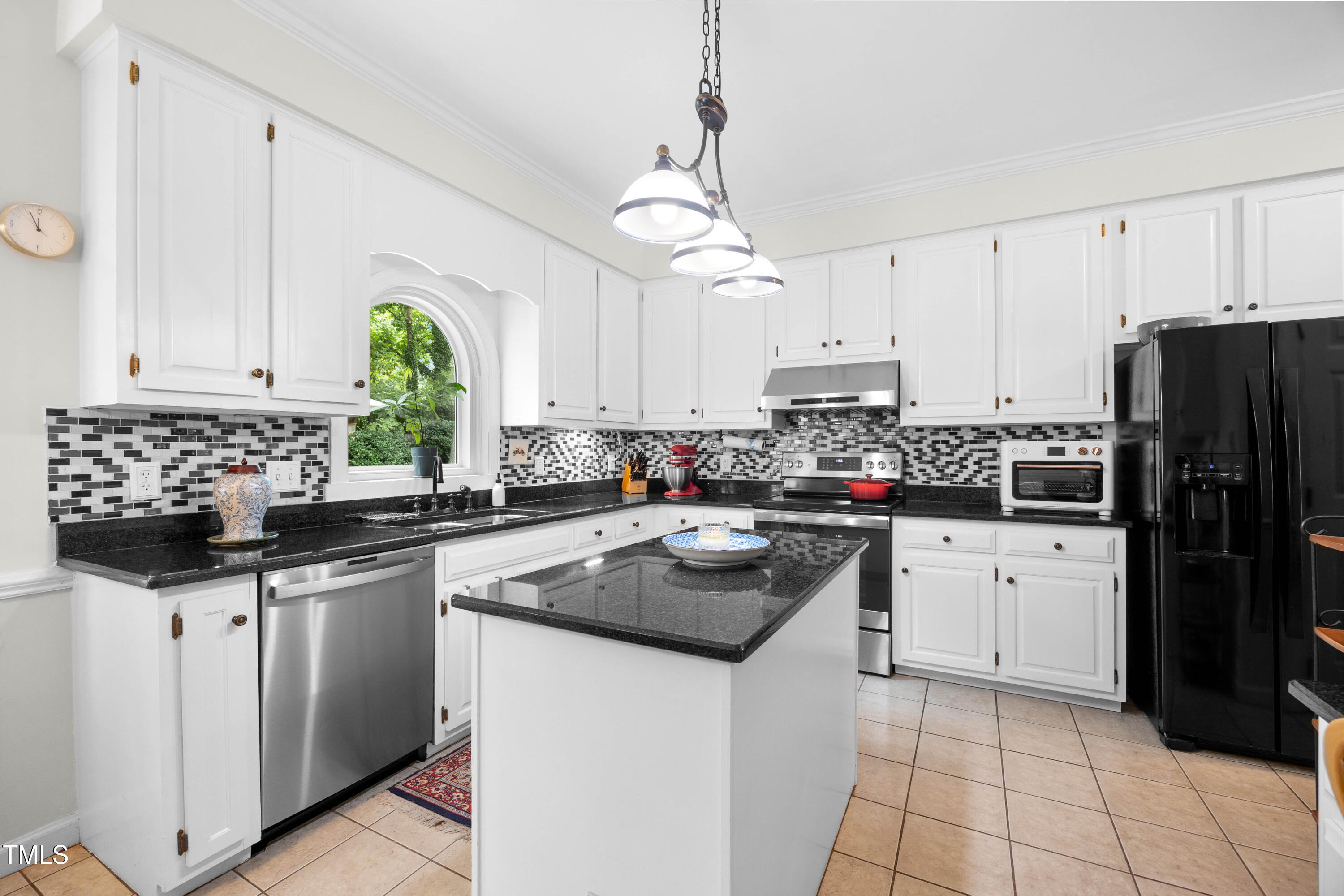 207 Wintermist Drive Cary, NC 27513 - Photo 11 of 43 a kitchen with stainless steel appliances granite countertop a sink a stove a refrigerator a kitchen island with white cabinets and a window